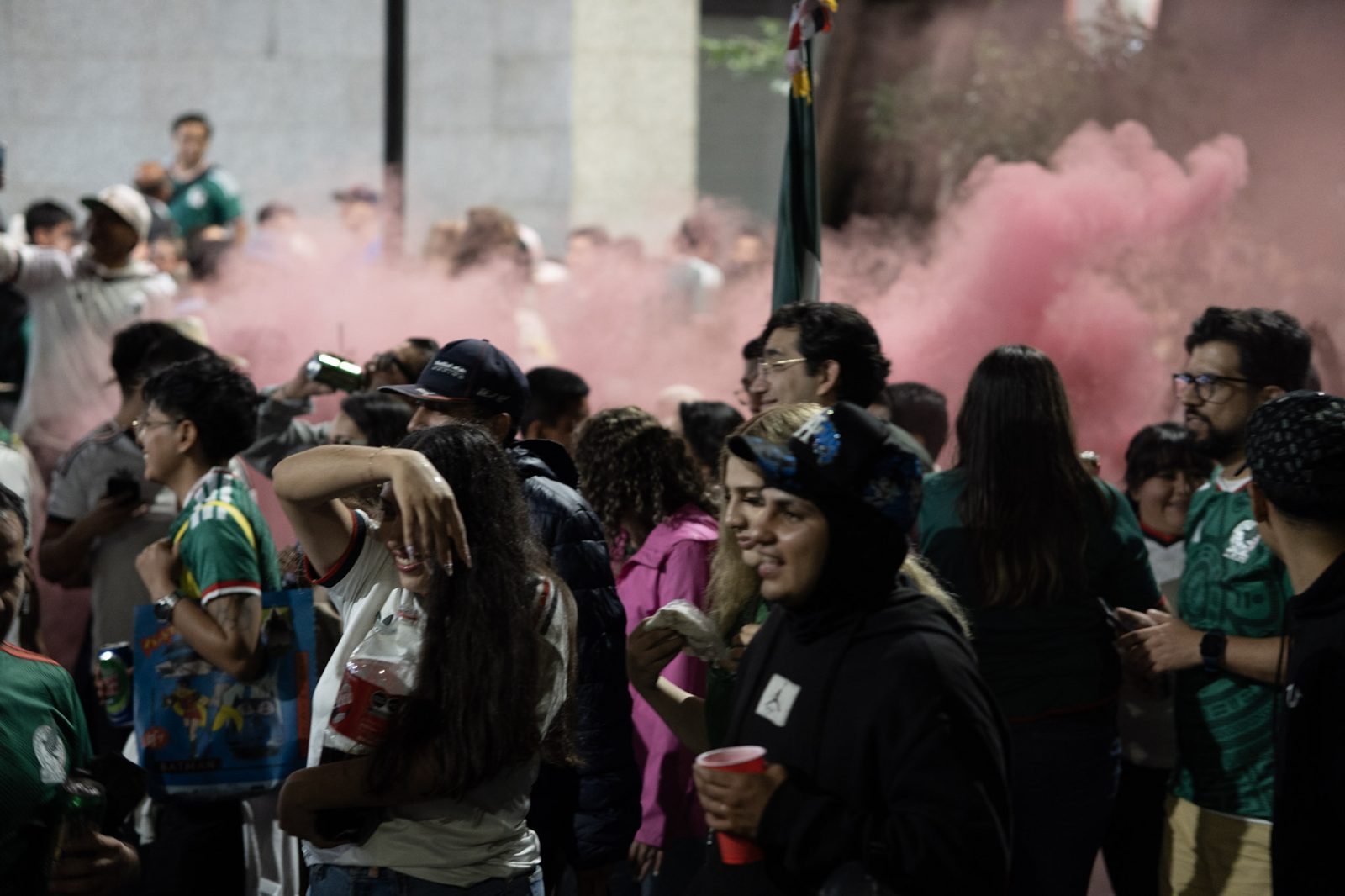 Pink smoke drifting over the celebrating crowd